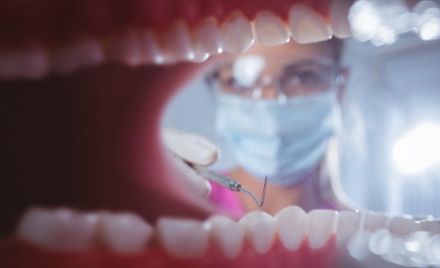 The view from inside a mouth as a dentist is checking to see if a patient needs a dental implant restoration.